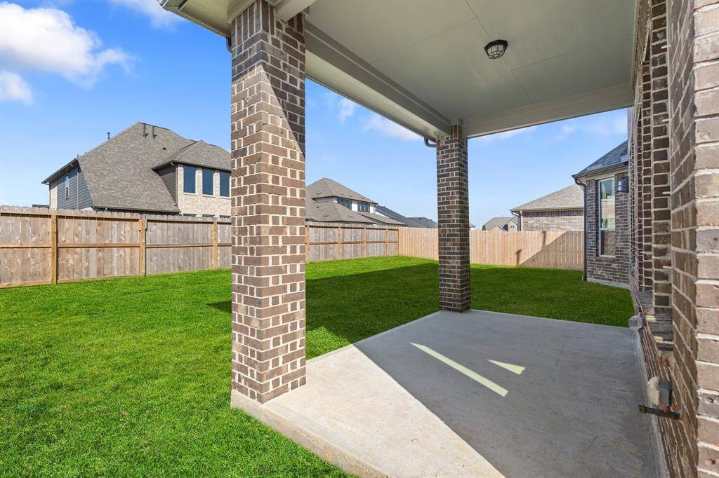 The covered patio is generously sized, providing ample space for various outdoor activities.