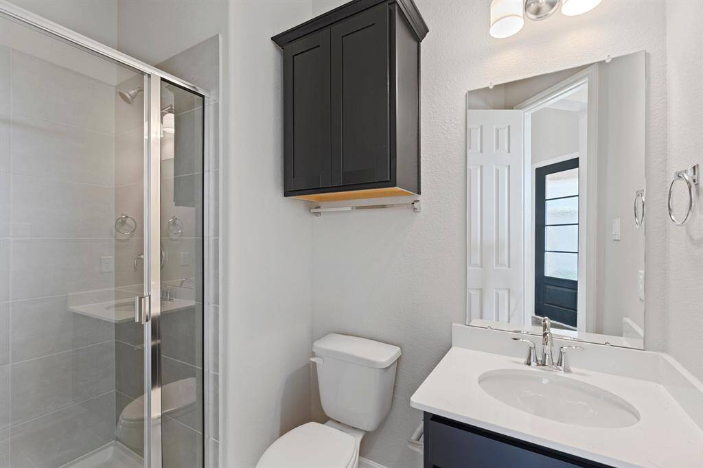 The secondary bath features tile flooring, white cabinetry and light countertops and a walk-in shower. Perfect for accommodating any visiting family and friends.