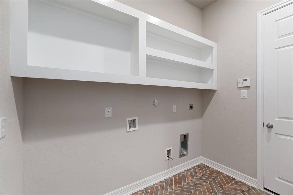 The laundry room layout is carefully planned for optimal workflow with designated areas for washing, drying, and storing.