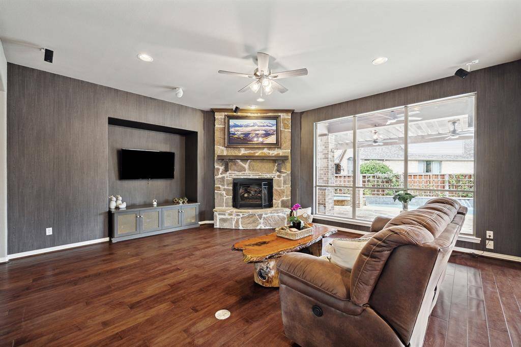 Large Den with stone fireplace, gorgeous wood flooring and a great view to the pool.