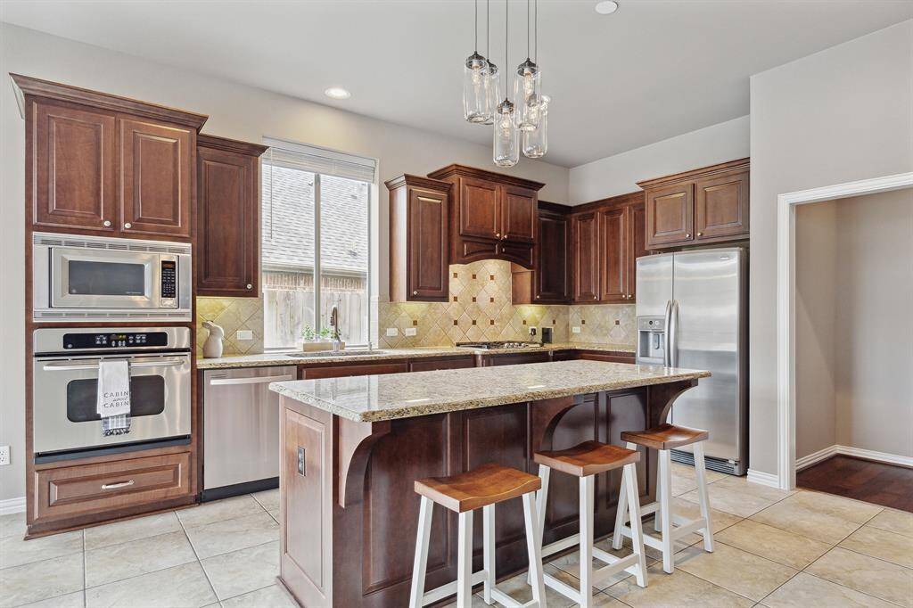 Kitchen is bright with lots of natural light.  Stainless steel appliances and granite counters and large tile flooring.