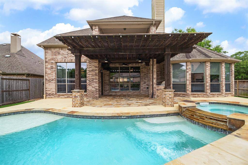 Detailed shot of the spillway and ledges in the pool. Stunning stone and brick work on the rear elevation of this house too.