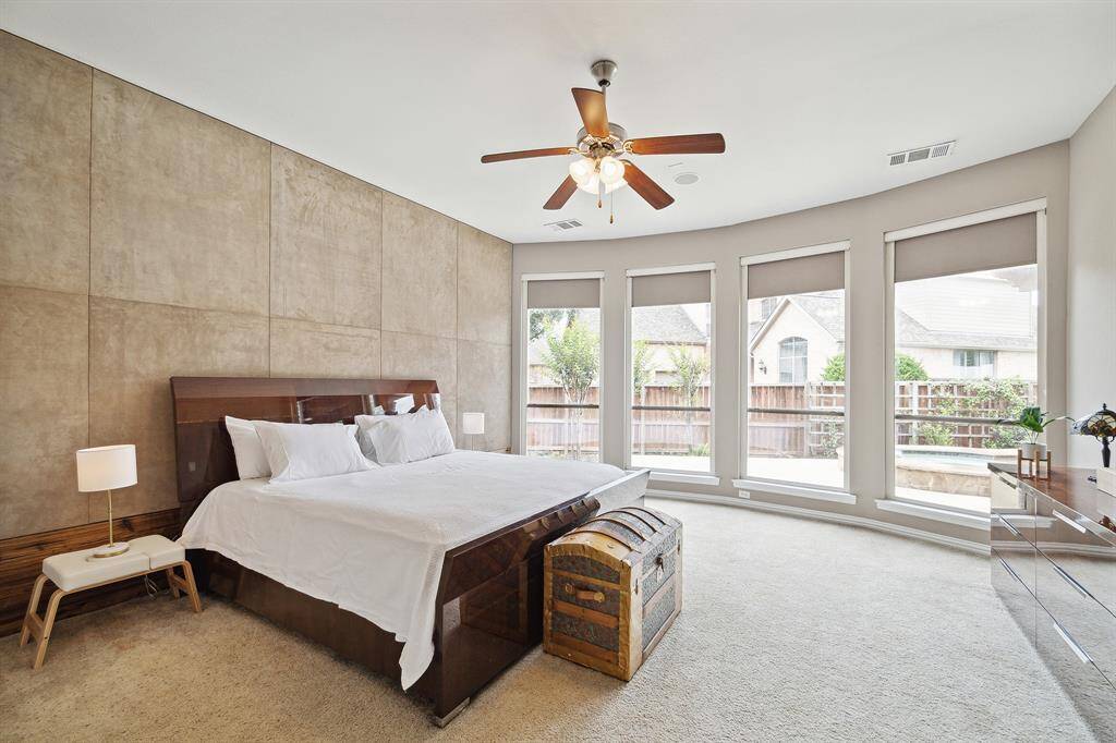 Large Primary Bedroom has a wall of windows with views of the pool.