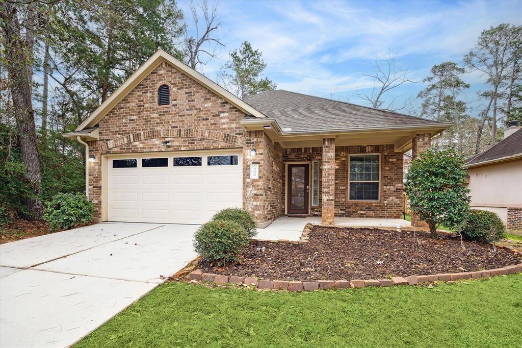 This charming brick home features a welcoming front porch, a two-car garage, and a neatly landscaped front yard. Nestled among mature trees, it offers a serene and private setting.
