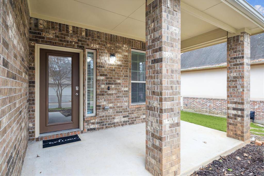 Welcoming brick front porch with a cozy space for outdoor seating.