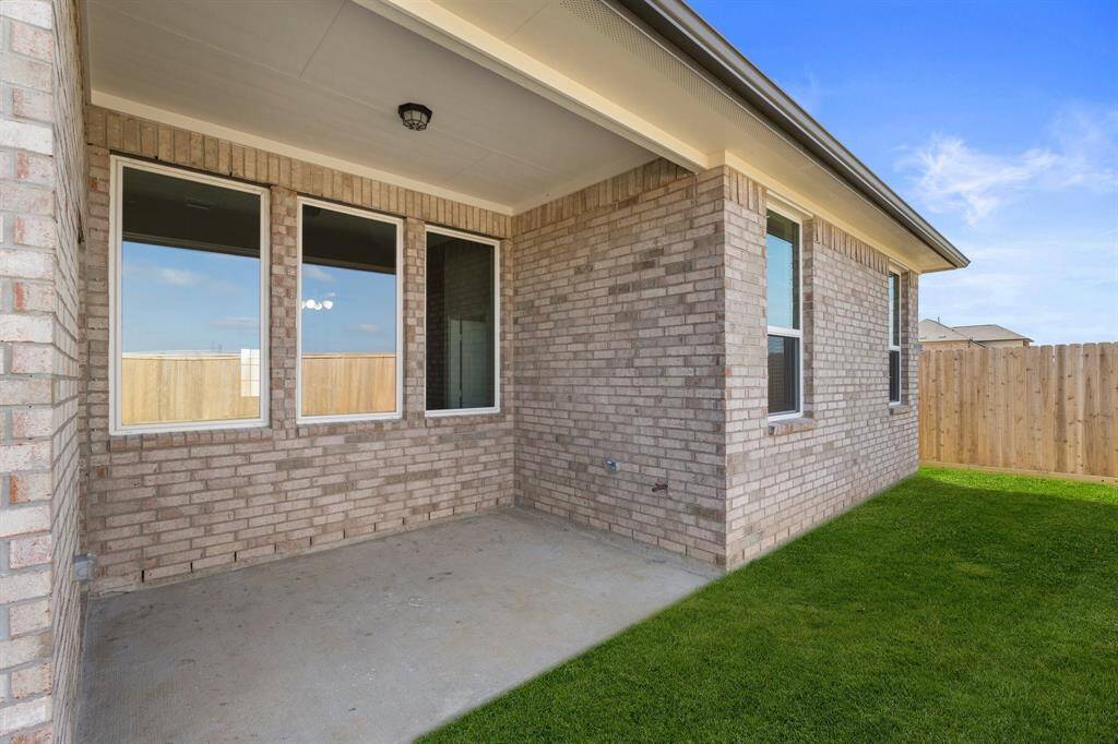 The covered patio is generously sized, providing ample space for various outdoor activities.