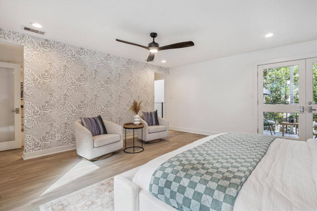 Primary bedroom has a seating area along a gallery wall that separates the bedroom from the primary bathroom. The other side of this wall offers a dual purpose, to create privacy & also allows for the new homeowner to display their Art.