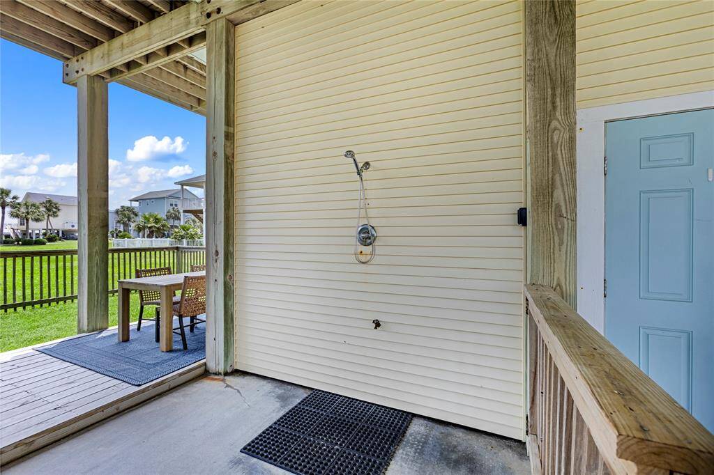 Outdoor shower and door leading to the garage storage area