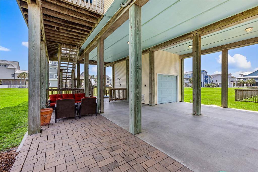 The lower level patio has an outdoor shower, conversation area and a one car garage with storage space