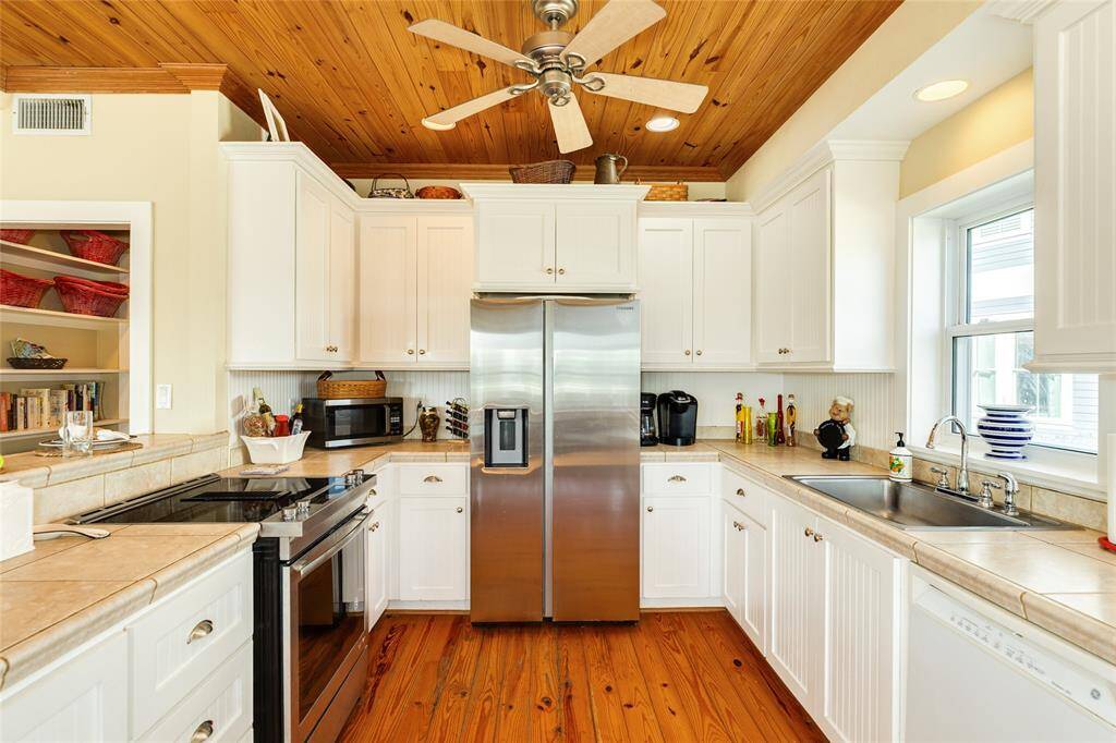 Tons of cabinets, ceiling fans, beautiful woodwork ceilings, jennair stove and stainless appliances.