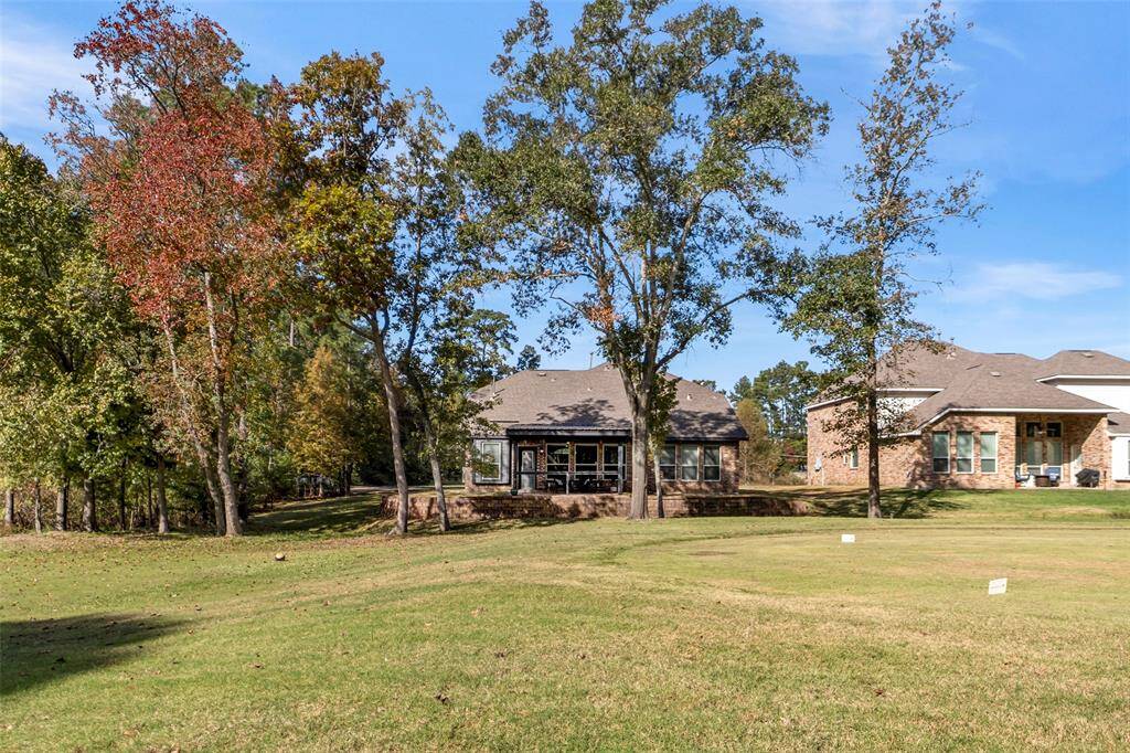View of home, and side empty lot from the golf course