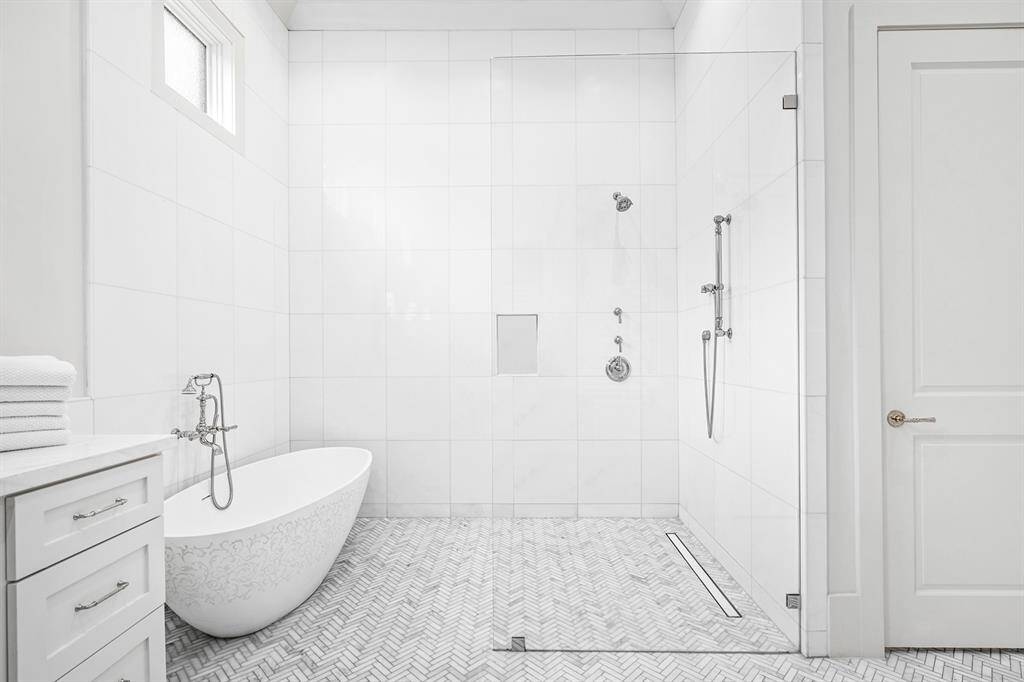 Huge walk-in frameless shower and separate artisanal etched acrylic soaking tub.