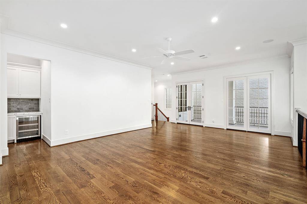 Expansive open game room located on the second floor with french doors to access balcony that overlooks courtyard. Dry bar with built-in beverage fridge.