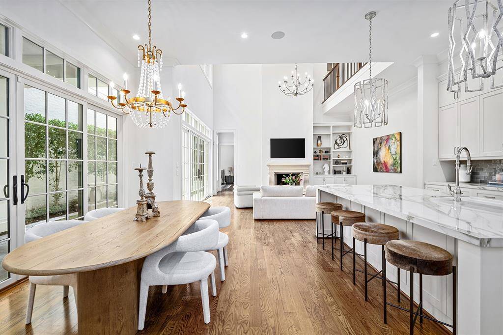Dining area with beautiful crystal chandelier, open to kitchen and living room. Wall of windows overlooking courtyard.