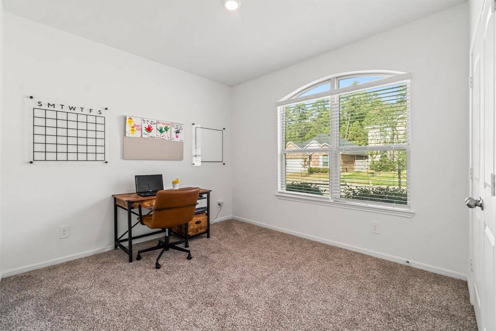 The front secondary bedroom, featuring cozy carpeting and a spacious closet, is currently used as a study, providing a quiet and versatile space perfect for work or relaxation.