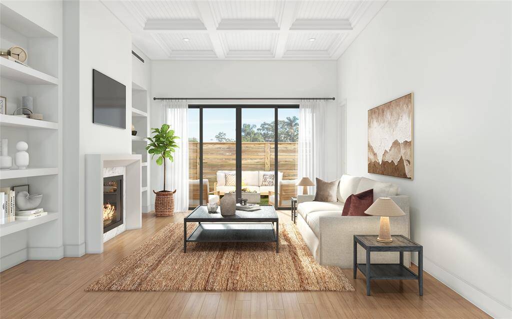 Open and Inviting - This Luxurious family room features a coffered ceiling, a brilliant fireplace flanked by shelving on both sides anchored by wide planked hardwood engineered floors. It exudes both warmth and sophistication Glass expanse doors open to the backyard seamlessly blending indoor outdoor living.