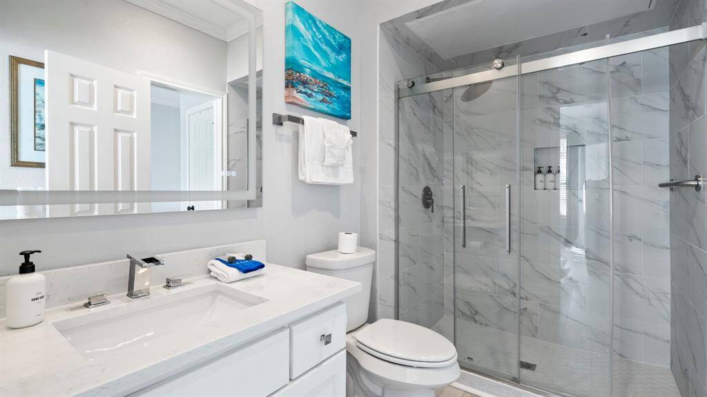 Quartz countertops, large walk-in shower, and luxury vinyl flooring complete the look.