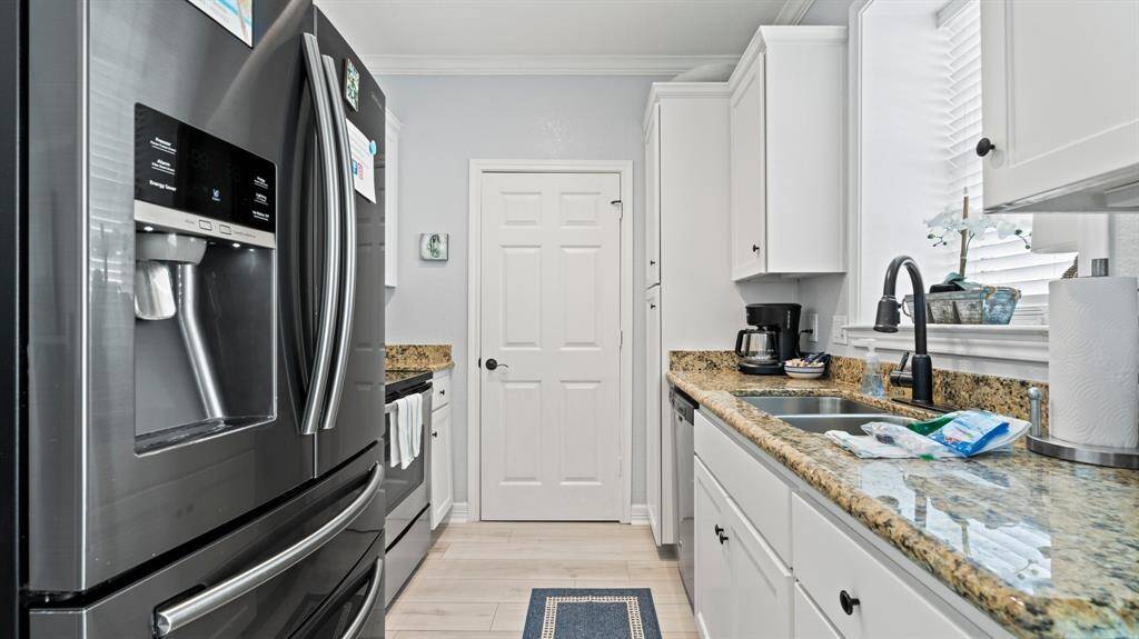 Galley kitchen features granite countertops and stainless appliances included.