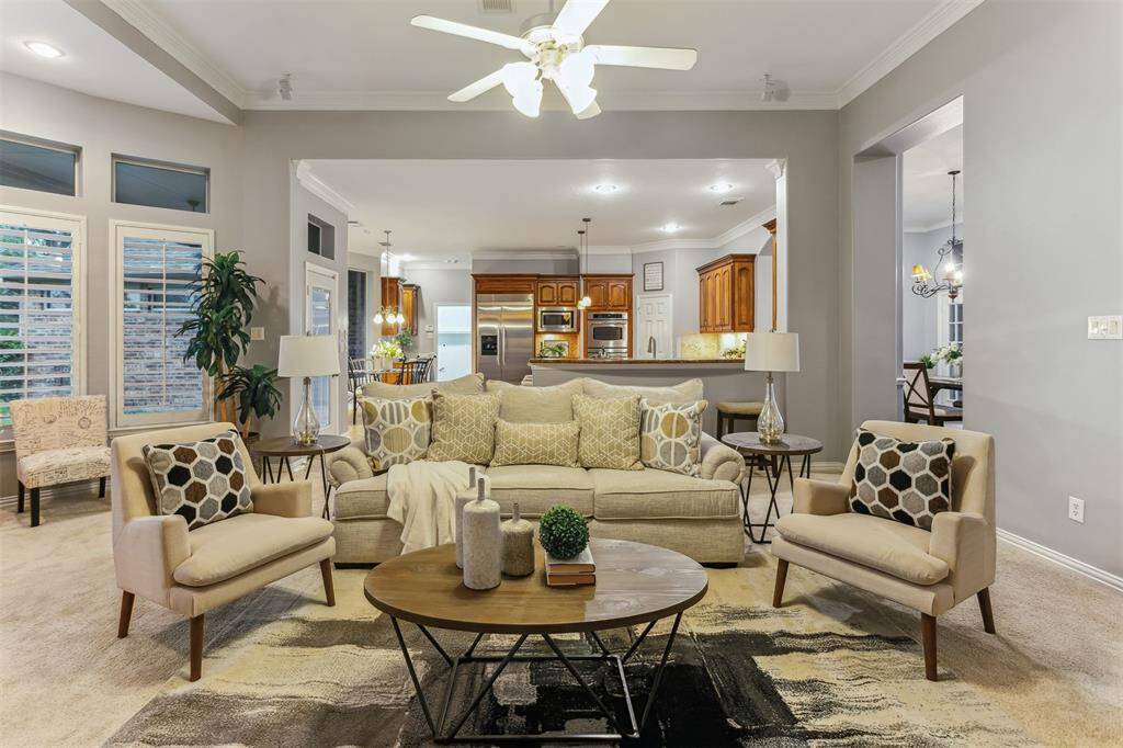 7014 Lake Haven Ct, Sugar Land Tx 77479-This inviting open-concept living space combines comfort and style, perfect for both relaxation and entertaining. The living room features a neutral color palette, accentuated by soft lighting and a modern ceiling fan. Large windows with plantation shutters provide ample natural light, enhancing the bright and airy atmosphere.