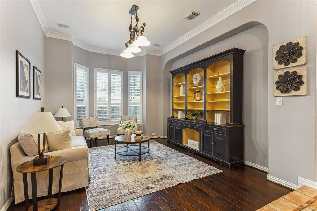 7014 Lake Haven Ct, Sugar Land Tx 77479-This beautifully designed living space offers a perfect blend of comfort and elegance. The room features large windows with plantation shutters, allowing natural light to fill the space and highlighting the high ceilings with intricate crown molding. The walls are painted in a soothing neutral tone, creating a calm and inviting atmosphere.