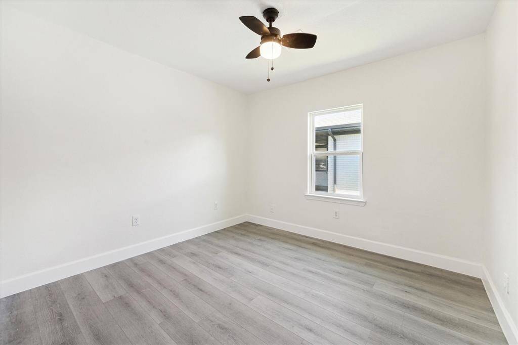 Secondary bedroom with laminate floors and ceiling fan.