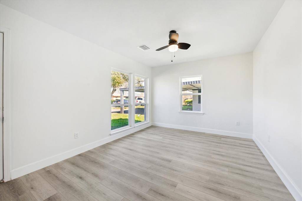 Secondary bedroom in front of home with large windows.