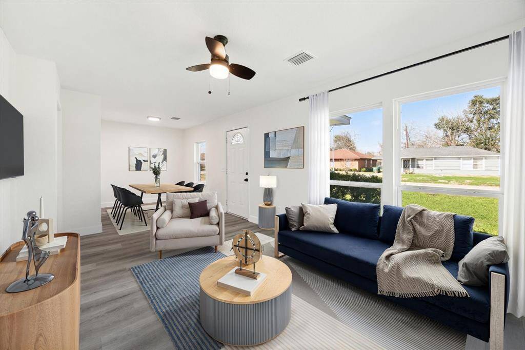 The living room is large and bright with oversized windows, and is open to the dining room.