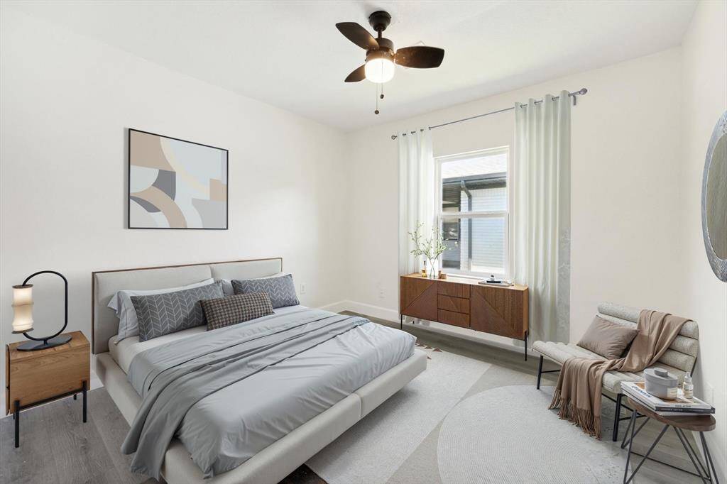 The large primary bedroom allows space for a seating area. It features a wide window and a walk-in closet.