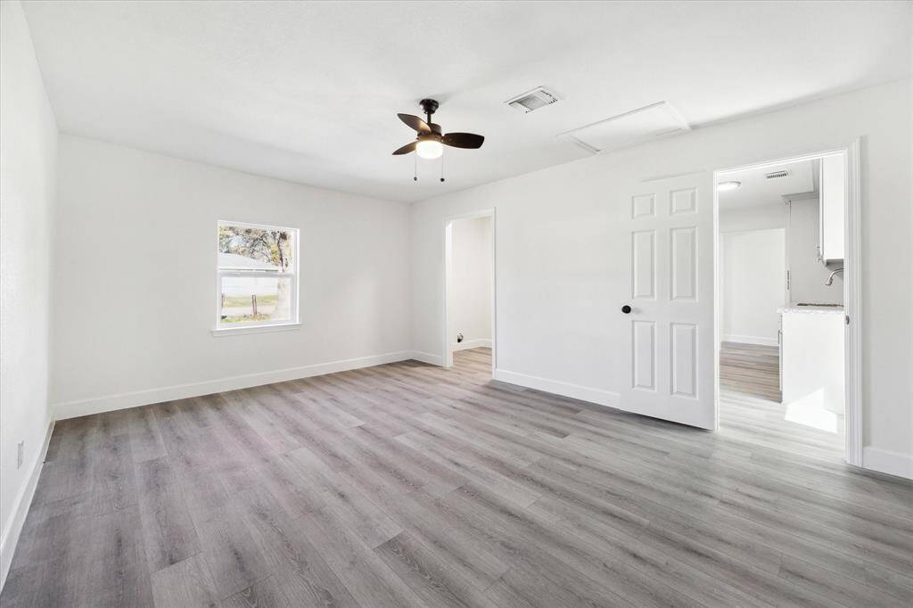 View of primary bedroom with walk in closet and full bathroom. Laminate floors in all bedrooms.