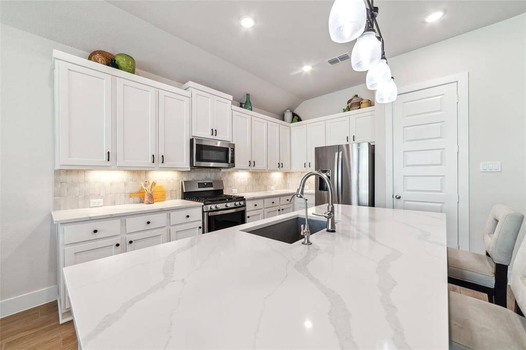 Gorgeous, timeless, and durable quartz countertops compliment your oversized kitchen island.