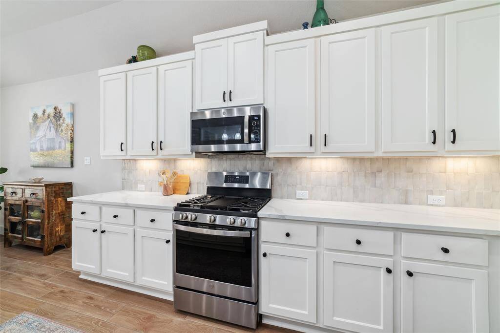 Alabaster white upgraded kitchen cabinets with hardware and under cabinet LED lighting