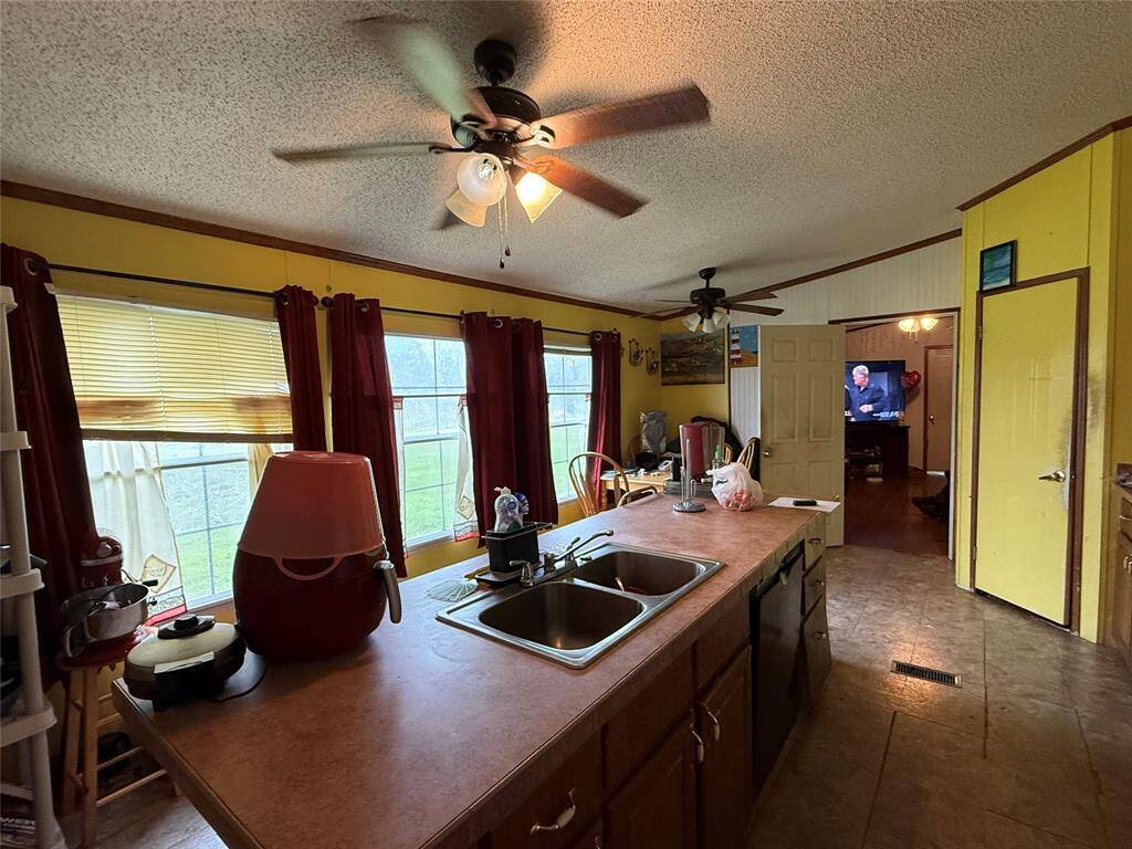 Kitchen island with breakfast nook on the right, doorway into den.