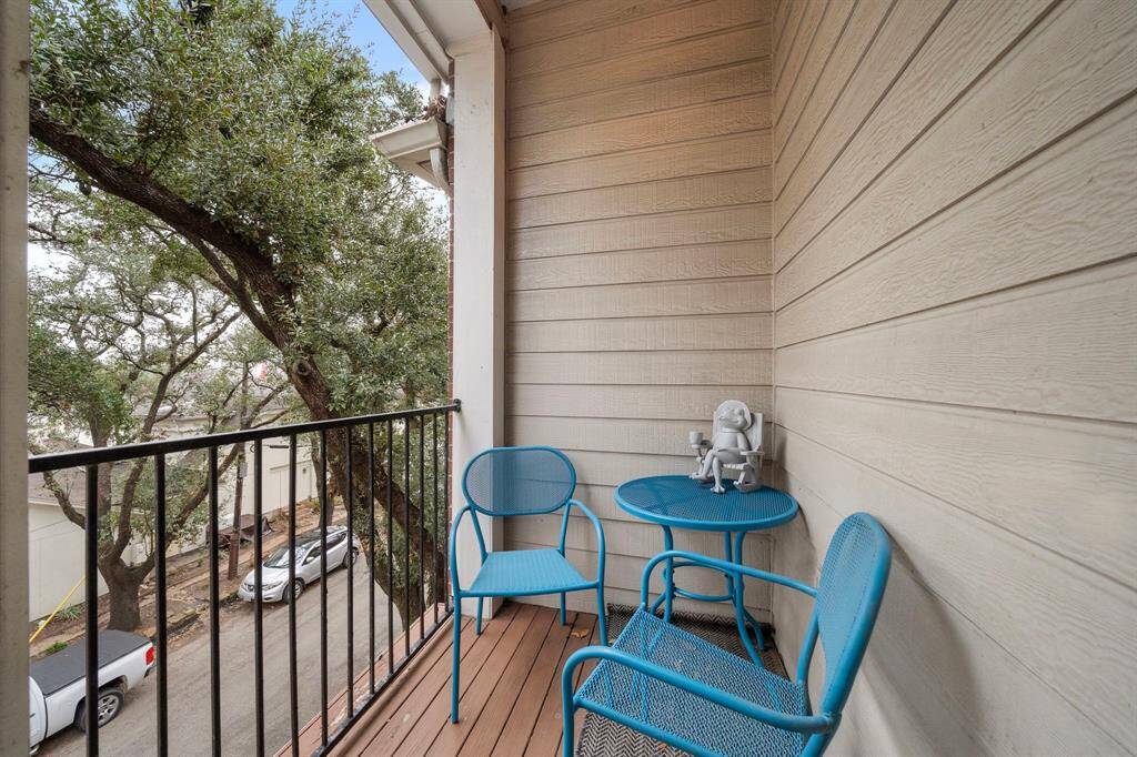 Updated wood-look floors & wrought iron railing enhance the outdoor balcony. A bistro set is ideal for enjoying morning coffee or a quiet evening outdoors.