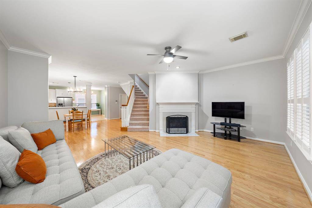 The light-filled living area opens seamlessly to the kitchen and breakfast nook via gleaming hardwood floors. This comfortable and inviting space is optimized by a staircase and a classic fireplace.