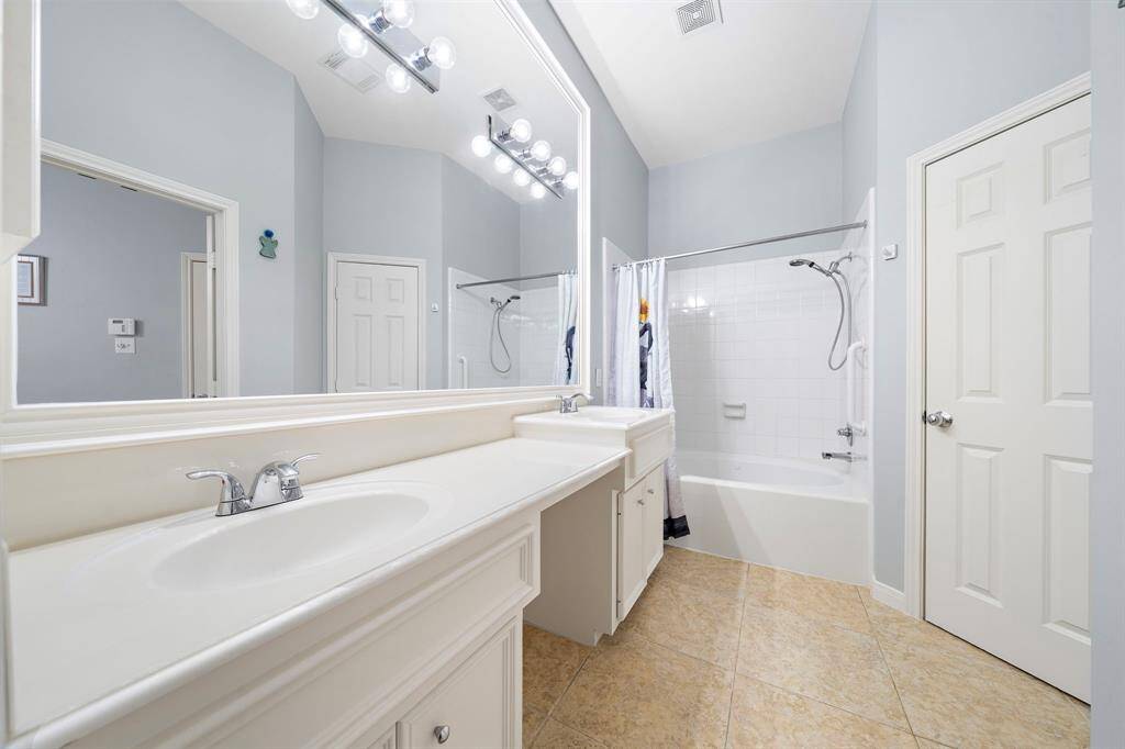 A dual sink vanity and updated fixtures define the shared bath. A tub-shower combination with easy to clean tile completes the space.