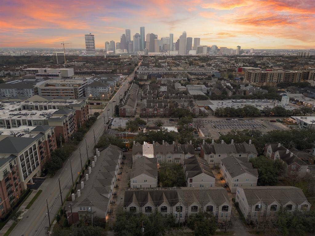 Panoramic aerial view of the townhome community. The city skyline is visible in the distance. Enjoy proximity to Buffalo Bayou or Downtown!