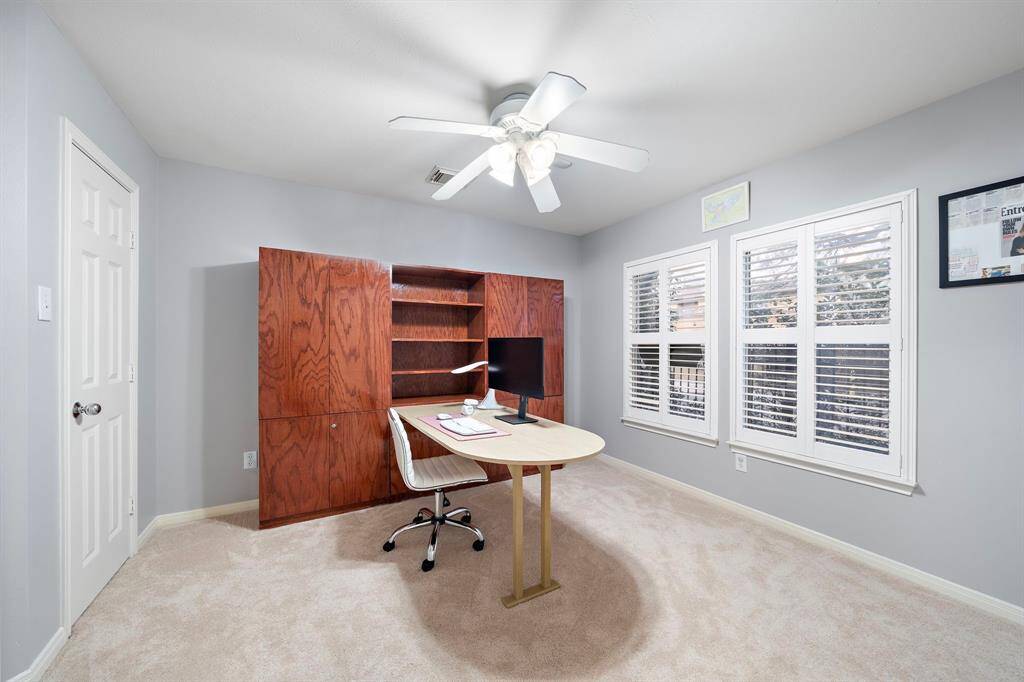 Functional bedroom area can be customized into a comfortable home office. The space features an open layout with warm carpet flooring and ample natural light, suitable for working remotely.