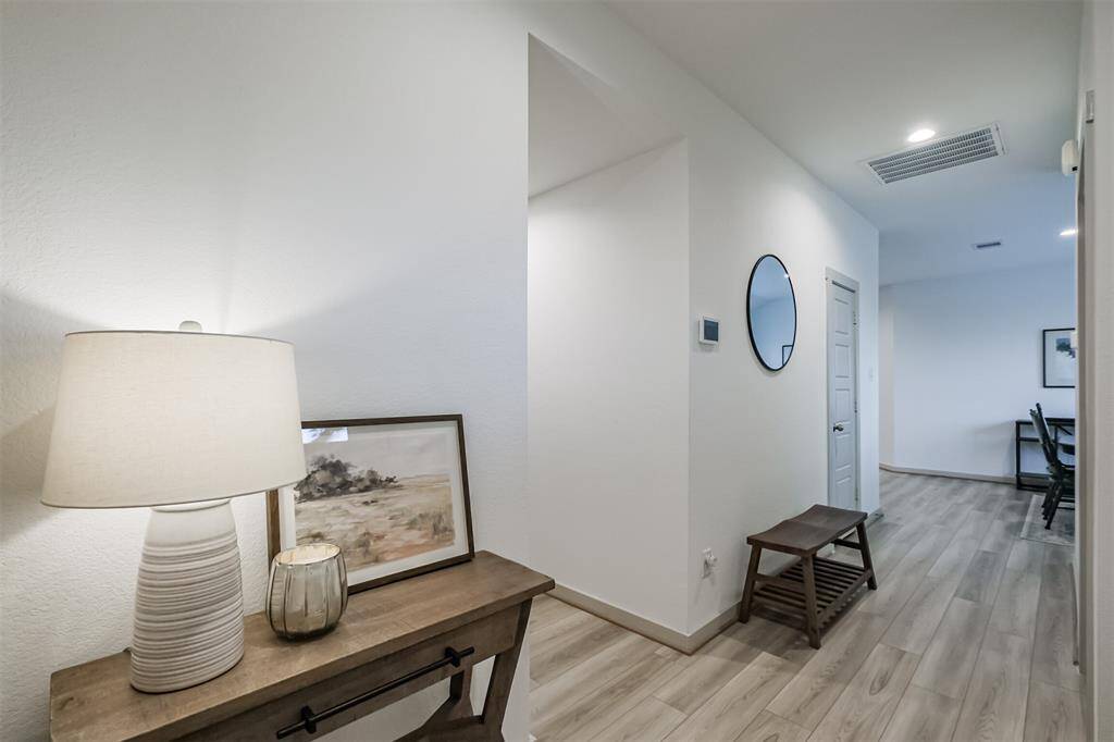 The front foyer delivers guests right into the heart of the home, with the dining area to the right and the secondary bedrooms to the left.