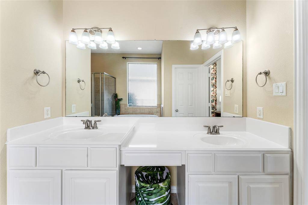 The primary ensuite features dual sinks set against elegant tile flooring, offering both convenience and style for a luxurious, functional space.