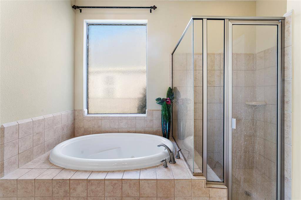 The primary ensuite is complete with a separate shower and a luxurious Jacuzzi tub, offering the perfect combination of relaxation and convenience for a spa-like experience.