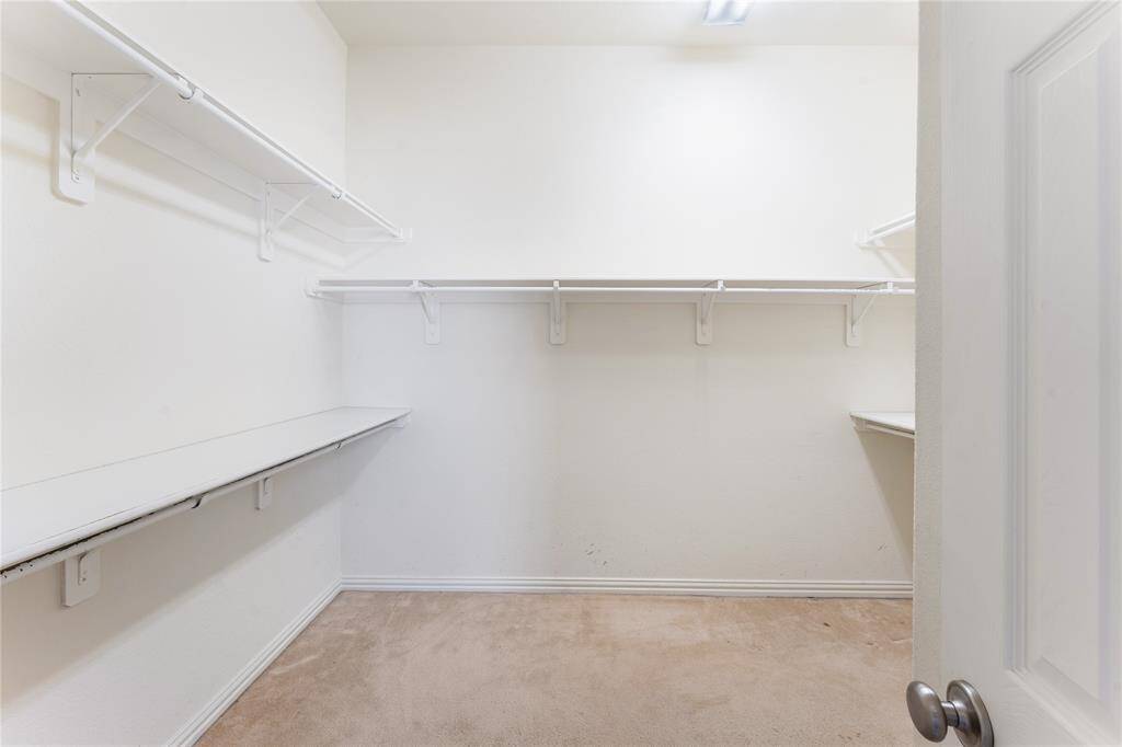 The spacious walk-in closet provides ample room for organization, with plenty of storage to keep your wardrobe neatly arranged and easily accessible.