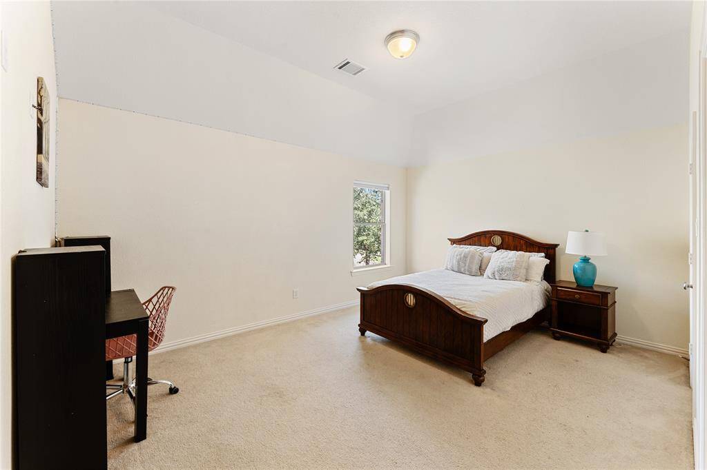 Secondary bedroom with plush carpeting and a walk-in closet.