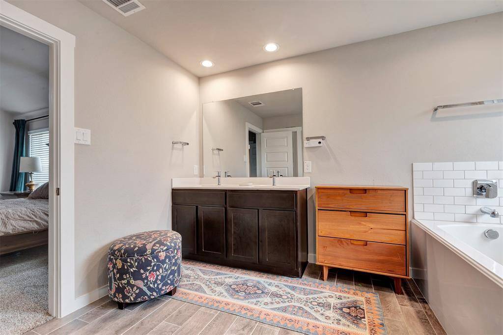 Bright bathroom with a large vanity mirror and ample drawers for convenient storage.