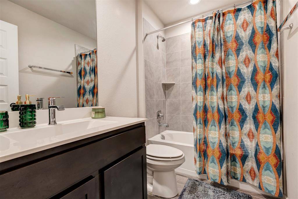 Another secondary bathroom with a tub and shower combo, offering the same convenient features as the other.