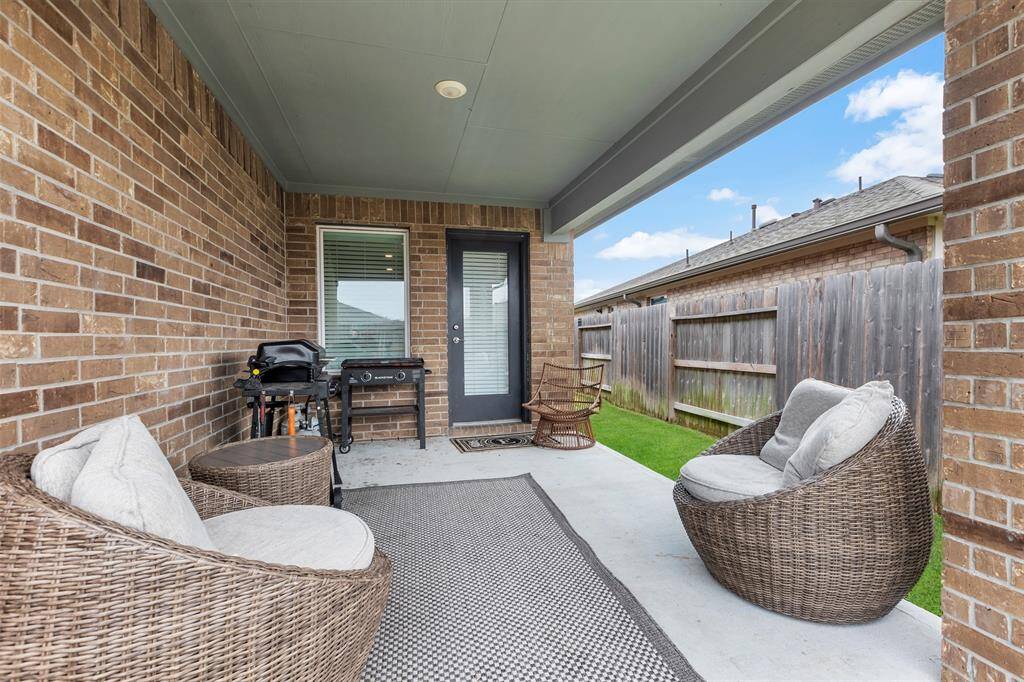 Charming back patio with a stylish brick wall.