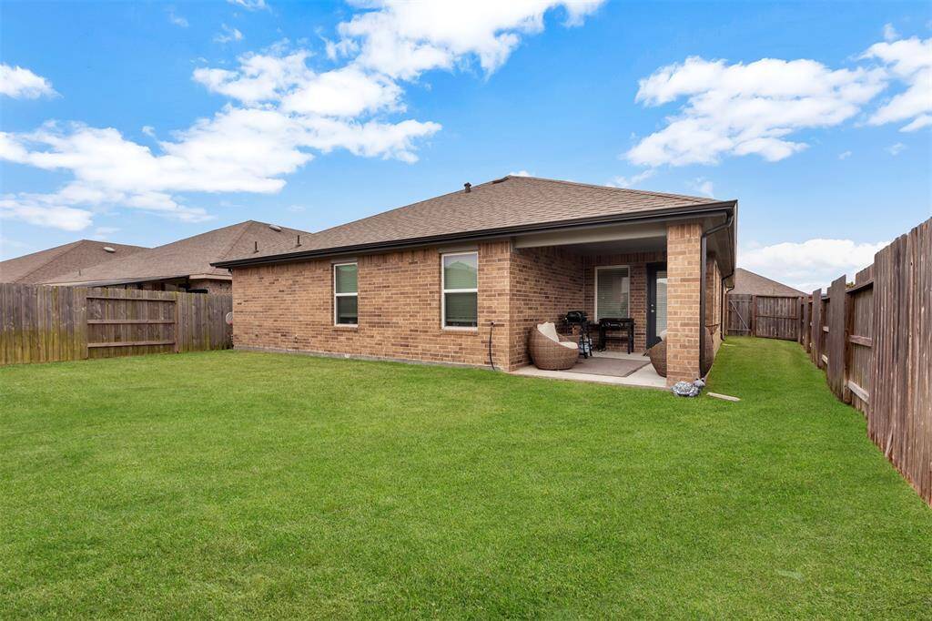 Tranquil backyard with lush green grass, fully enclosed by a tall wooden fence for privacy.