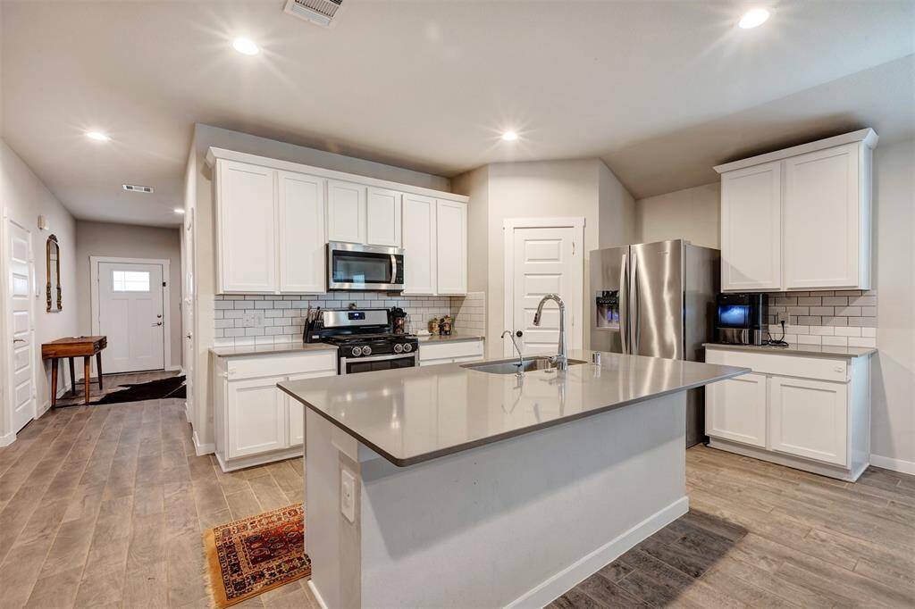Modern kitchen featuring a sleek granite-top island with a convenient single sink.