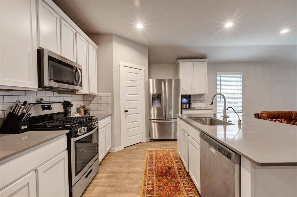 Plenty of storage with spacious kitchen cabinets and a hidden pantry behind the closed door.