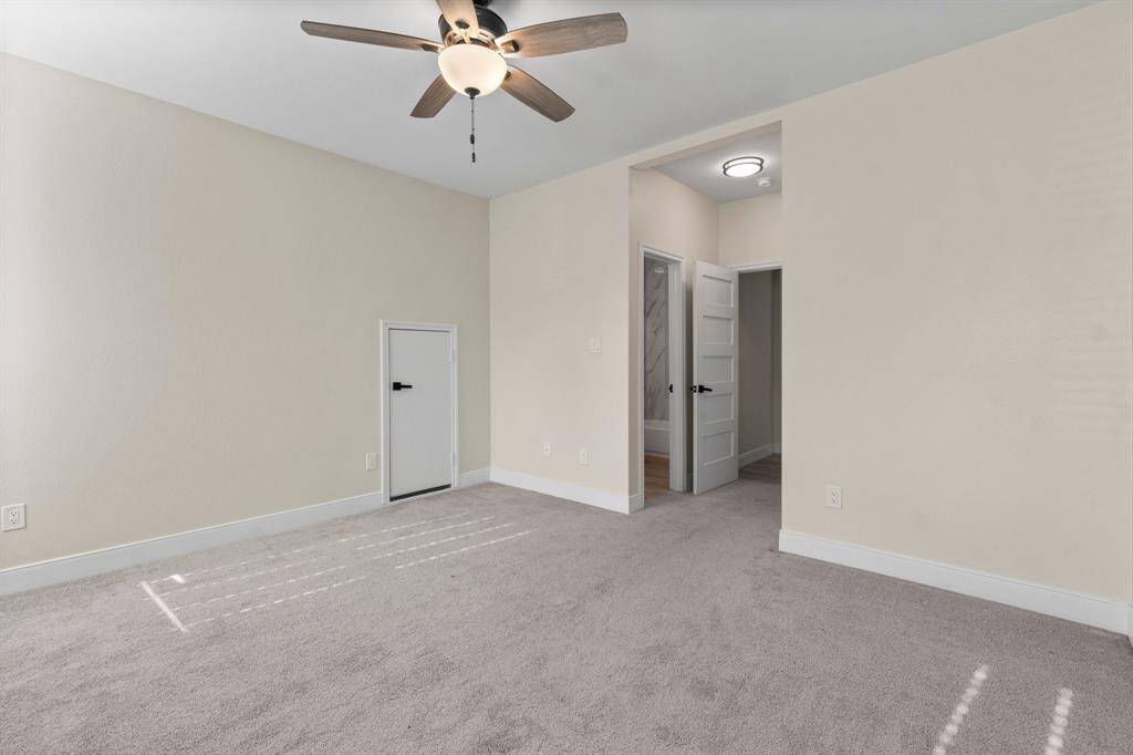 This room features carpet, a ceiling fan. The space is well-lit and has a clean, modern feel.
