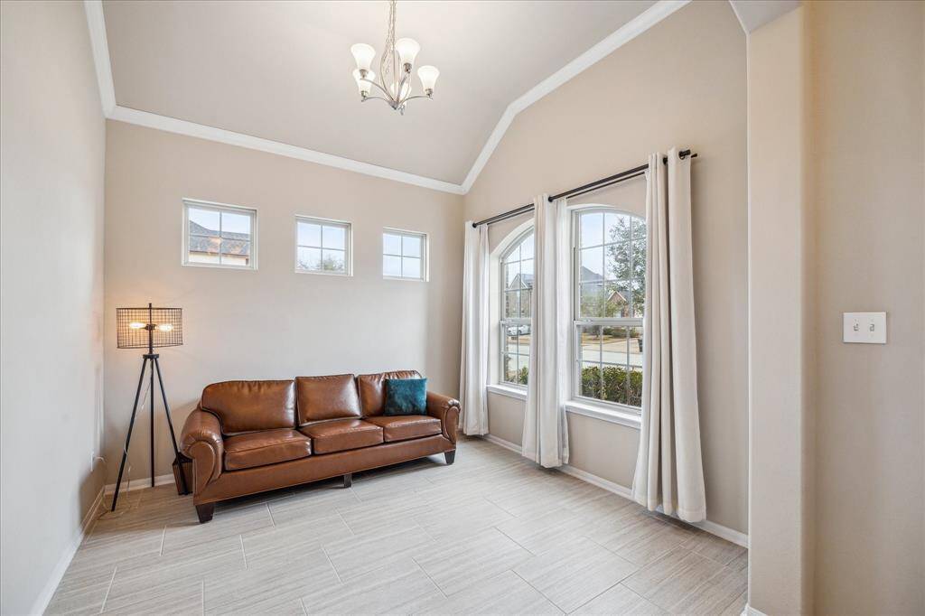 Bright and inviting living room with high ceilings, with large windows that provide ample natural light and a view of the neighborhood.